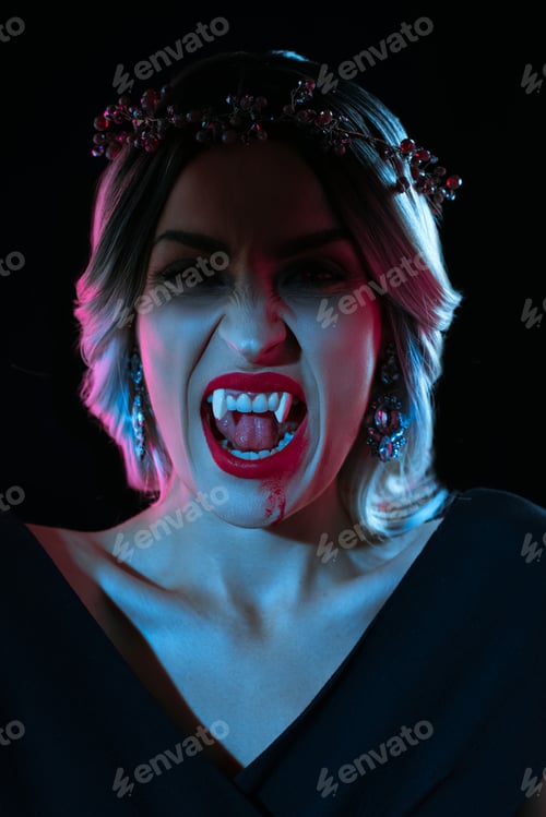 Preview: vampire woman showing vampire teeth isolated on black