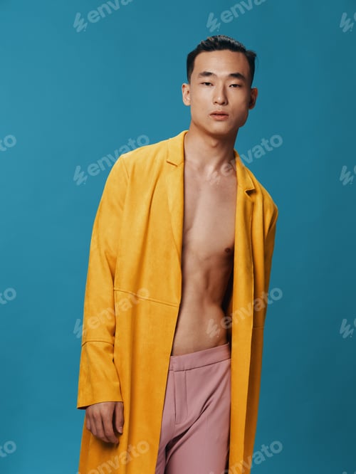 Preview: Handsome guy in a yellow jacket on a nude torso and a blue background pink pants model