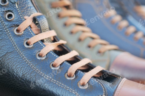 Preview: Close-up view of stylish black sneakers with brown laces