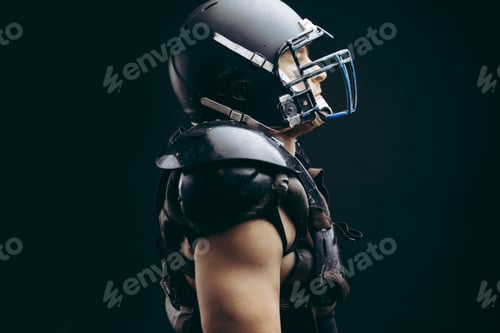 Preview: American football player with ball wearing helmet and protective shields
