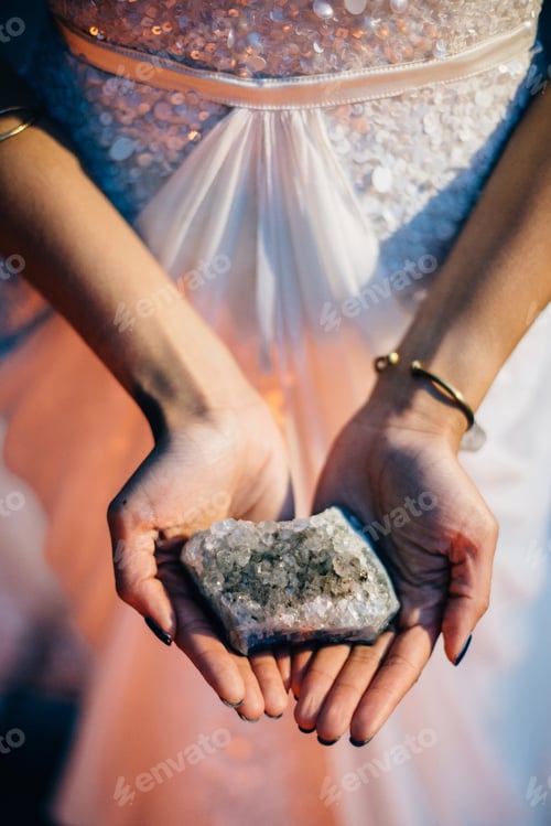Preview: Bride holding quartz crystal, mid section