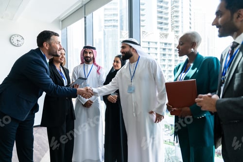 Preview: Multiethnic business team sealing deal with handshake in dubai office
