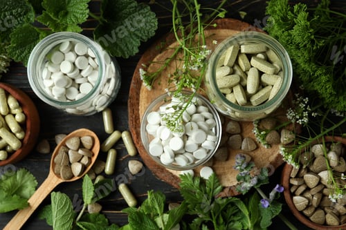 Preview: Concept of herbal medicine pills on wooden table, top view
