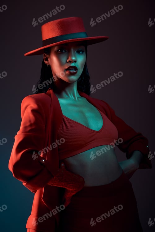 Preview: Fashion, red aesthetic and woman in dark studio with neon background in trendy, stylish and cool ou