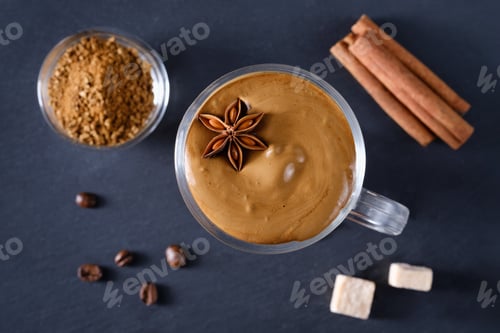 Preview: Whipped dalgona coffee with spices on a dark background. Korean coffee drink. Flat lay composition
