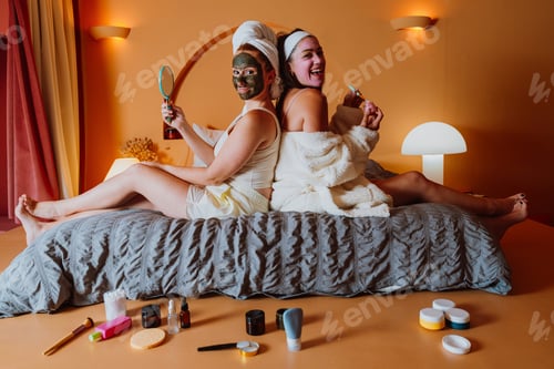 Preview: Two young women applying beauty masks and relaxing on bed