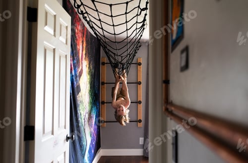 Preview: A cool, unique, child’s bedroom / playroom with a young kid hanging upside down from the ceiling.