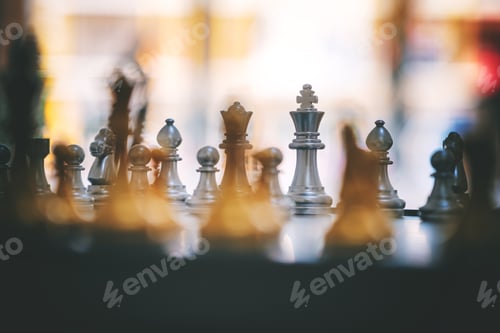 Preview: Closeup image of a silver and golden color chess set on chessboard