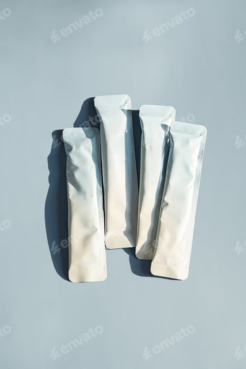 Preview: Several white sachet packages with copy space on light blue background.