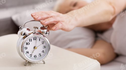 Preview: Person Reaching Out To Turn Off Vintage Alarm Clock