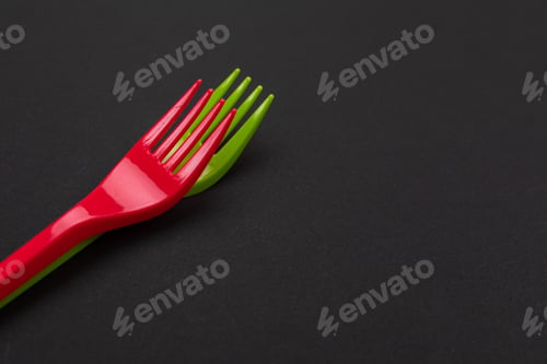 Preview: Disposable red and green plastic forks isolated on background