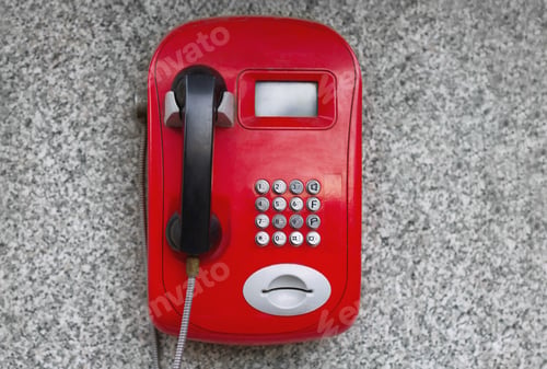 Preview: red metal phone, automatic, payphone hangs on the wall on a city street