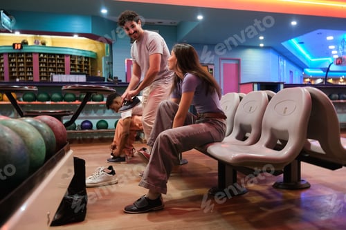 Preview: Friends putting on bowling shoes preparing to play together