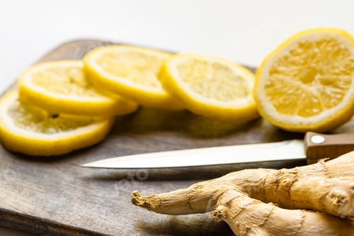 Preview: Selective Focus of Hot Ginger Root, Lemon on Wooden Cutting Board With Knife on White Background