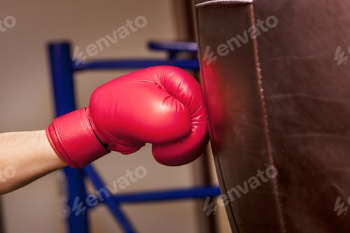 Preview: Close-up hand of boxer at the moment of impact on punching bag