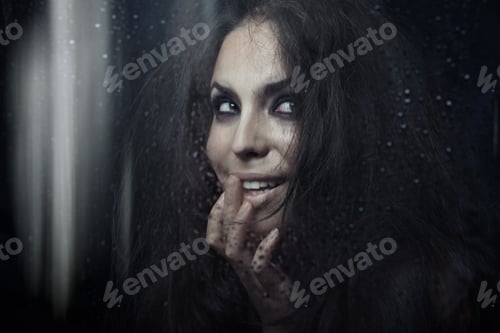 Preview: Smiling witch behind the window wet after the rain