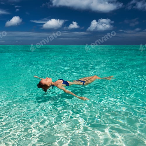 Preview: Woman In Bikini Lying On Water At Tropical Beach
