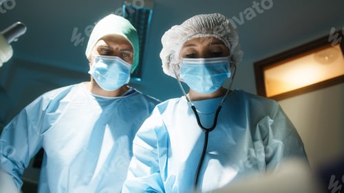 Preview: Doctor and nurse lay a surgical drape over the patient