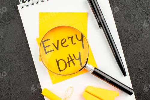 Preview: top view lupa on every day written on sticky note pen scroll sticky note on spiral notepad on dark