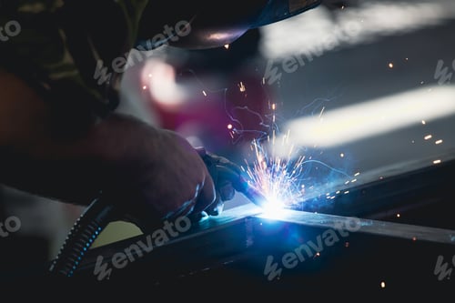 Preview: Industry worker welding iron pieces at work