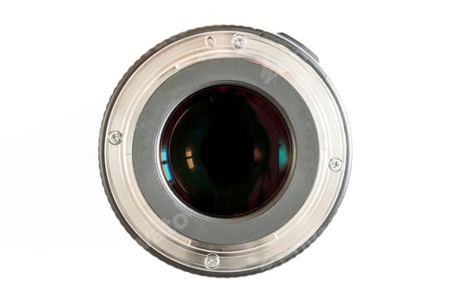 Preview: Camera photo lens close-up on white background with lense reflections.