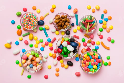 Preview: different colored round candy in bowl and jars. Top view of large variety sweets and candies