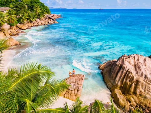 Preview: Anse Patates, La Digue Seychelles, young couple men and woman on a tropical beach during a luxury