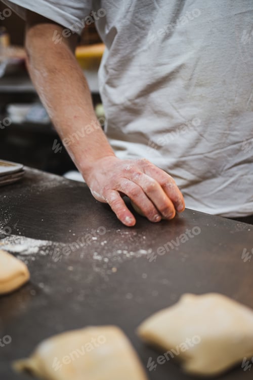 Preview: Man kneading bread dough in a bakery