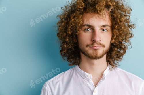 Preview: Young man with ginger curly hair posing and looking at camera