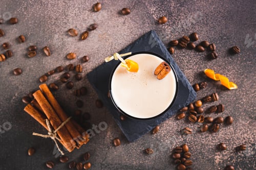 Preview: Close up of spanish coffee cocktail with cinnamon and orange zest in a glass on table top view