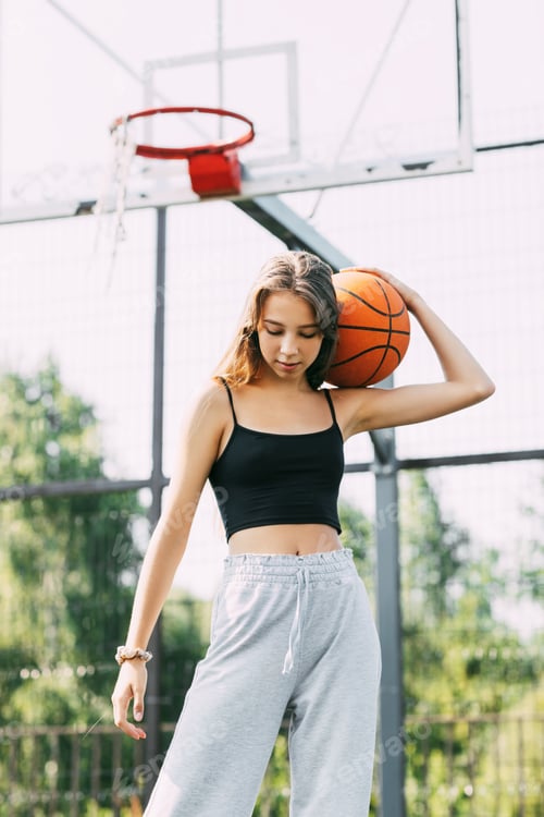Preview: Portrait of young female basketball player. Beautiful teen girl playing basketball. in sportswear