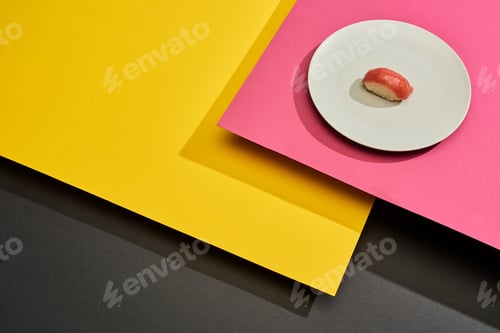 Preview: fresh nigiri with tuna on plate on black, pink, yellow surface