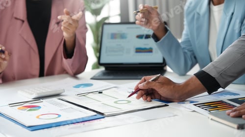 Preview: Business team members are having a discussion about financial data, using charts and graphs