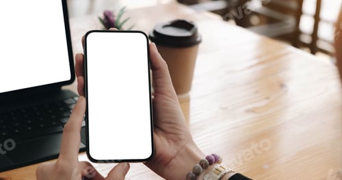 Preview: Mock up, businesswoman holding blank screen mobile smart phone and browsing internet on laptop