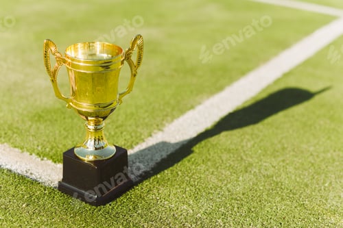 Preview: Golden prize cup for winner of competition on tennis court lawn