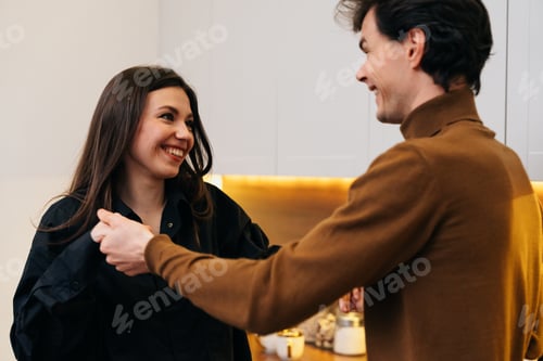 Preview: Joyful interaction between a couple in a modern kitchen setting