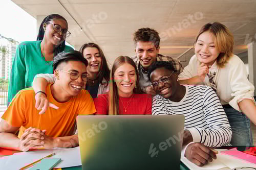 Preview: Big group of young students using a laptop to do the homeworks at high school library. Teenagers e
