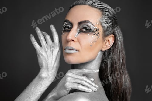 Preview: Portrait of a beautiful woman with silver paint on her skin and hair