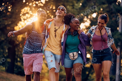 Preview: Cheerful group of friends walking embraced while going to open air music festival.