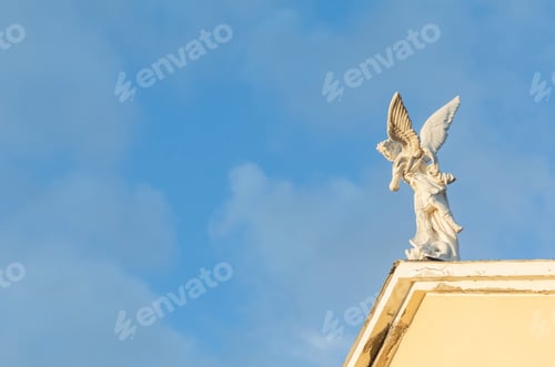 Preview: Saint Michael the Archangel statue placed on top of a church with blue sky