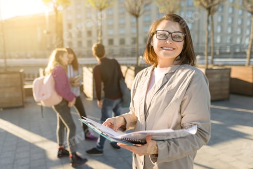 Preview: Portrait of mature smiling female teacher in glasses with clipboard