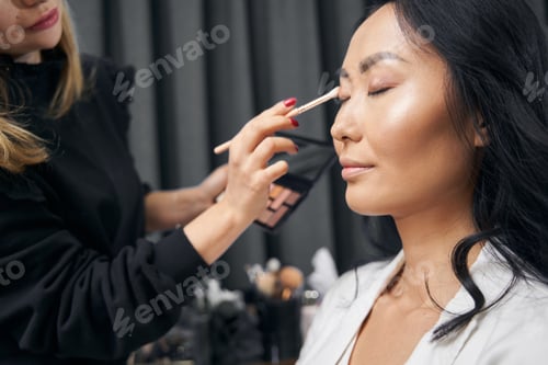Preview: Charming Asian female receiving makeup in beauty center