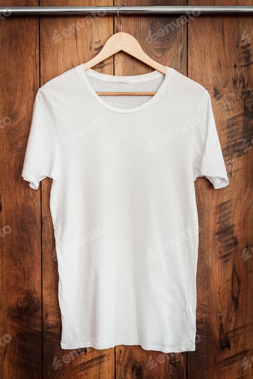 Preview: White T-shirt. Close-up of white T-shirt hanging against wooden grain