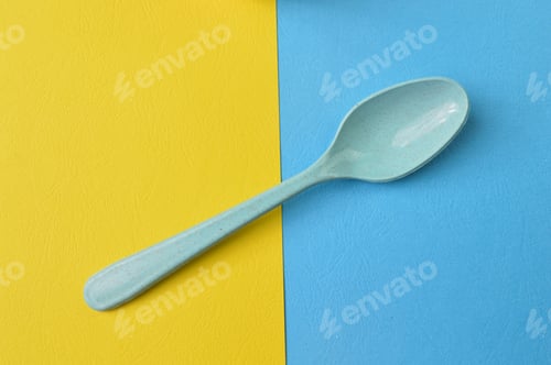 Preview: Green spoon isolated on yellow and blue background. Minimalistic concept