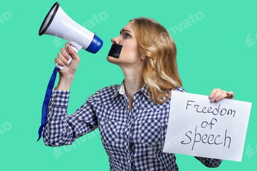 Preview: Young blonde woman holding megaphone and banner with freedom of speech inscription.