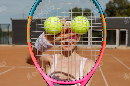 Preview: Female Tennis Player Holding Two Balls Behind Racket Closeup Court View