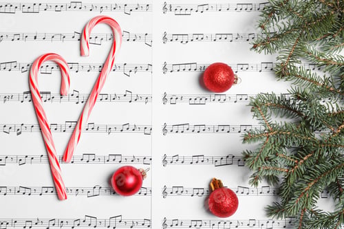 Preview: Composition with candy canes and Christmas balls on music sheets, top view