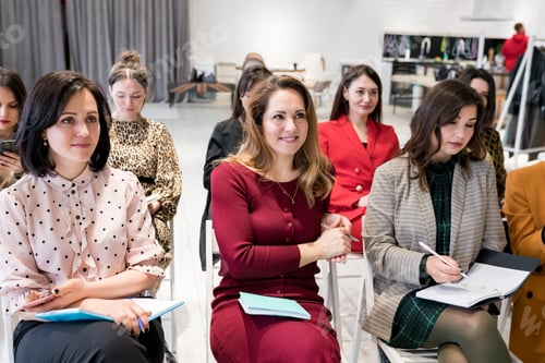 Preview: Group of females sitting in the audience for business training. Women outlining coach speech in note