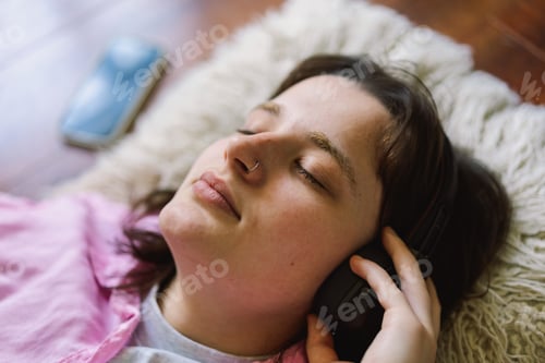 Preview: Teengirl Relaxing on the Floor With Headphones and a Drink
