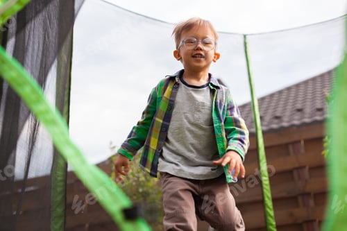 Preview: Child jumping on trampoline in the backyard